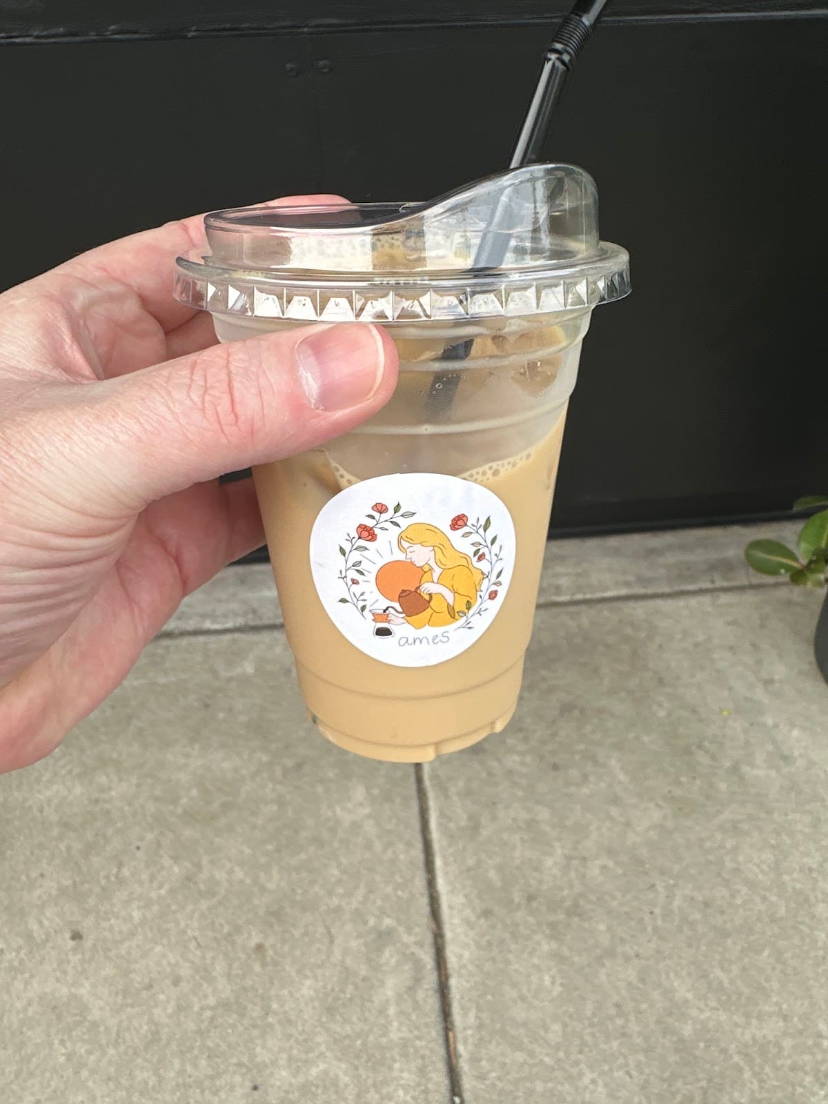 Iced coffee cup with the ames coffee circular dog-and-floral sticker