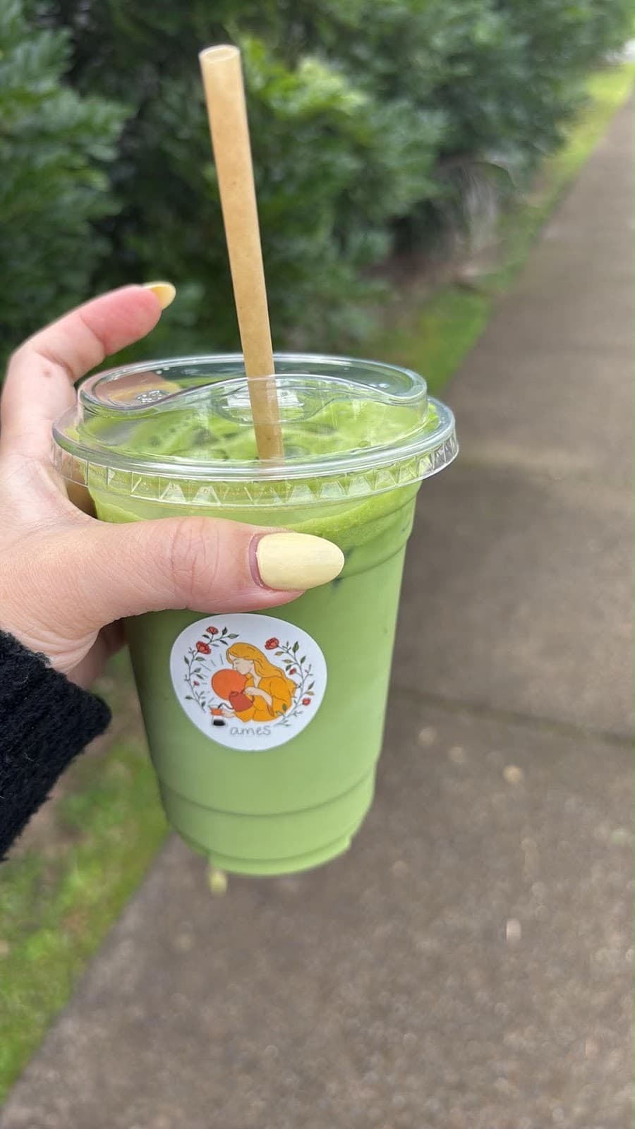 Walking away from ames coffee with an iced matcha and a bamboo straw